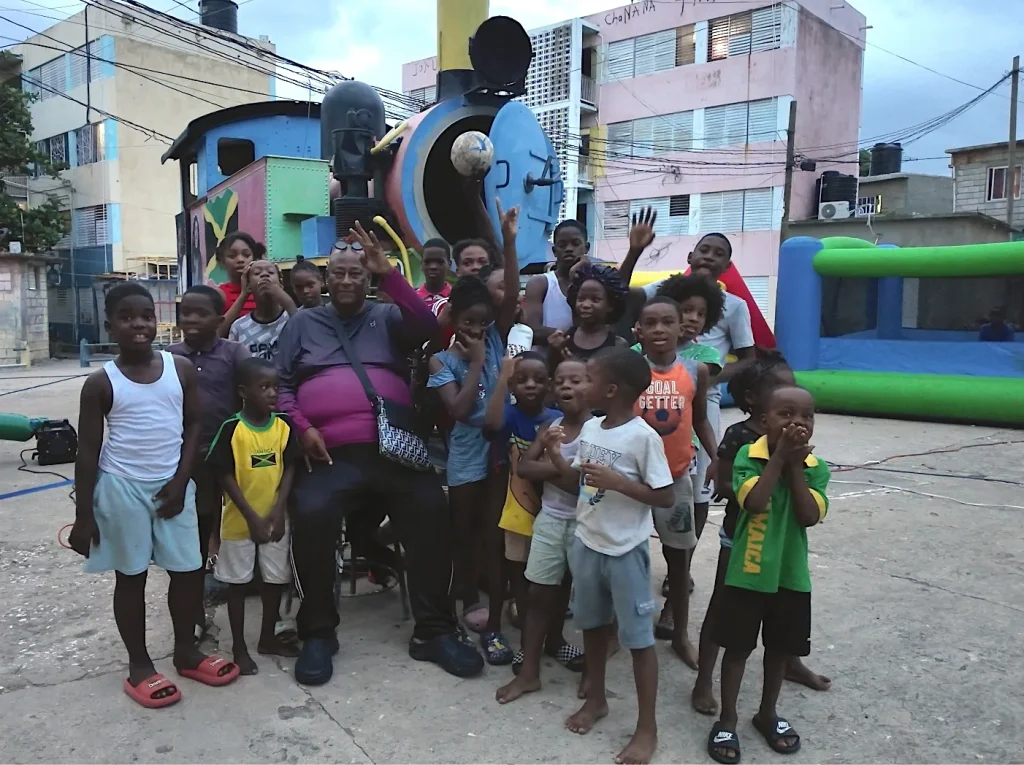 Chuchu Benz surrounded by children during the Foundation’s first Give Back in Trench Town, Jamaica.