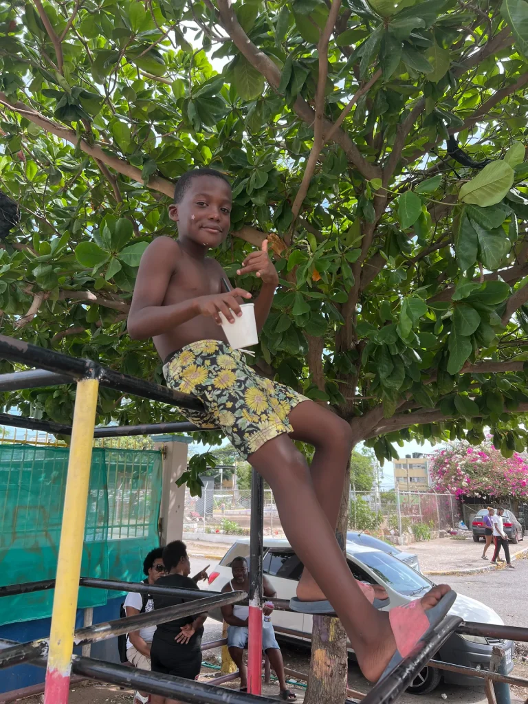 Smiling child holding a cup during the Chuchu Benz Foundation Give Back in Trench Town, Jamaica.