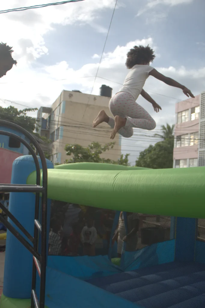 Child jumping and playing on an inflatable during the Chuchu Benz Foundation Give Back in Trench Town, Jamaica
