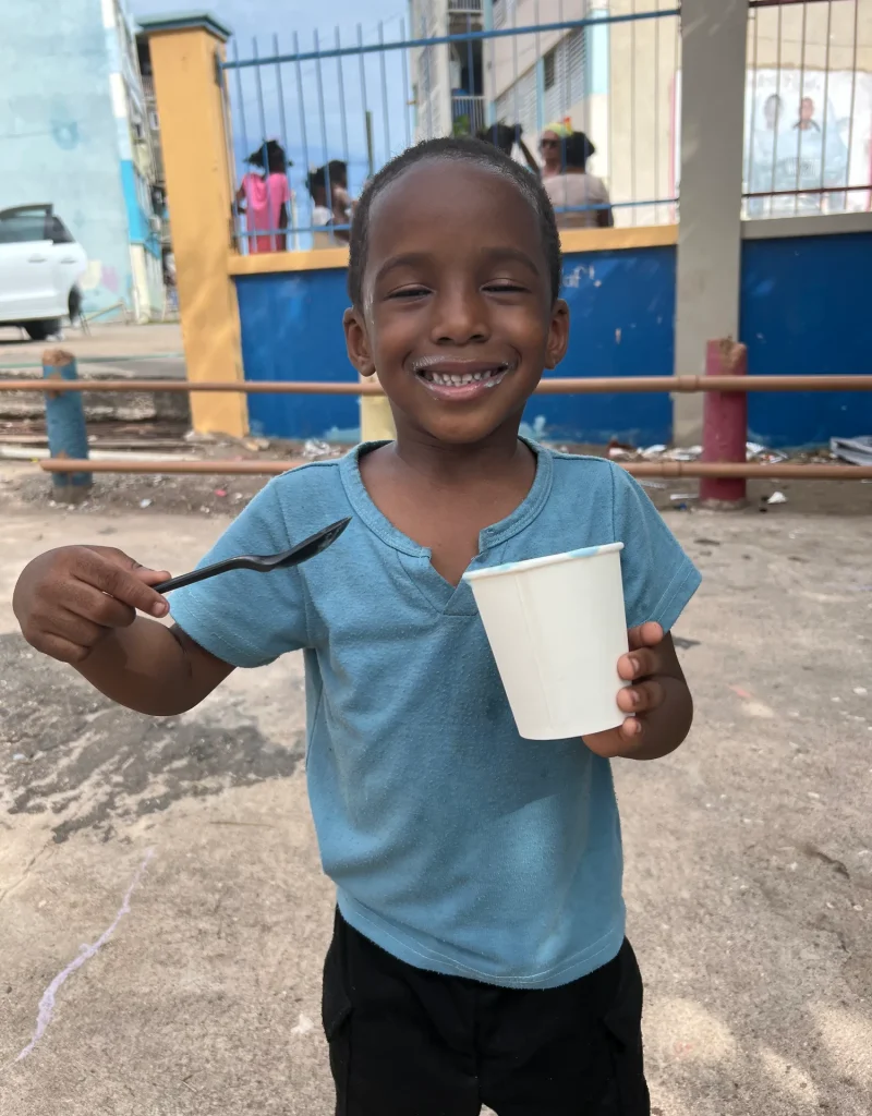 Smiling child enjoying the Chuchu Benz Foundation Give Back in Trench Town, Jamaica