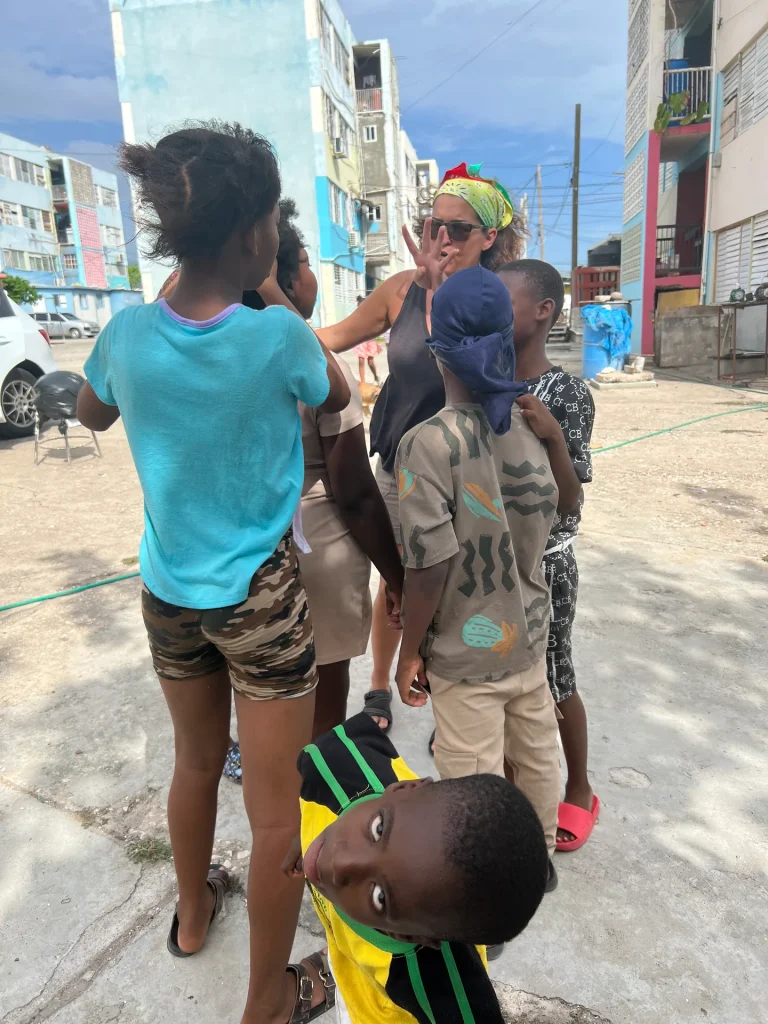 Children and community members gathering during the Chuchu Benz Foundation Give Back in Trench Town, Jamaica.