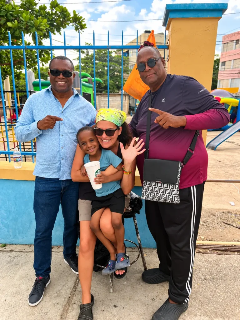 Community members posing together during the Chuchu Benz Foundation Give Back in Trench Town, Jamaica.