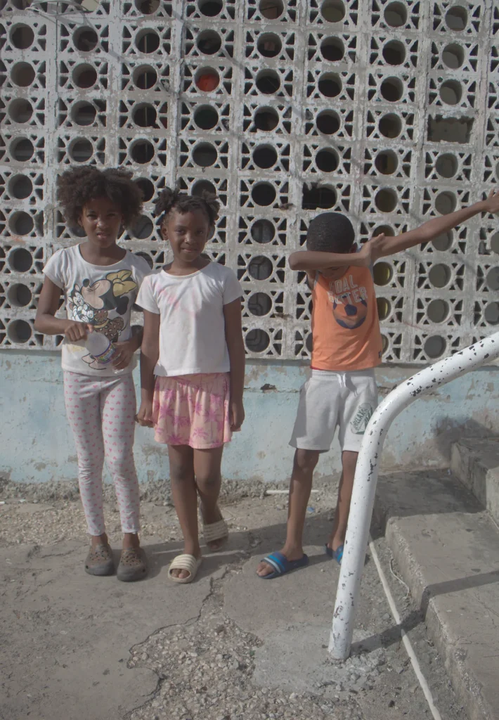 Three children posing together during the Give Back in Trench Town, Jamaica.